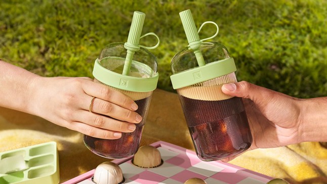 Two models cheersing their iced coffee beverages in Nspresso Tumbler